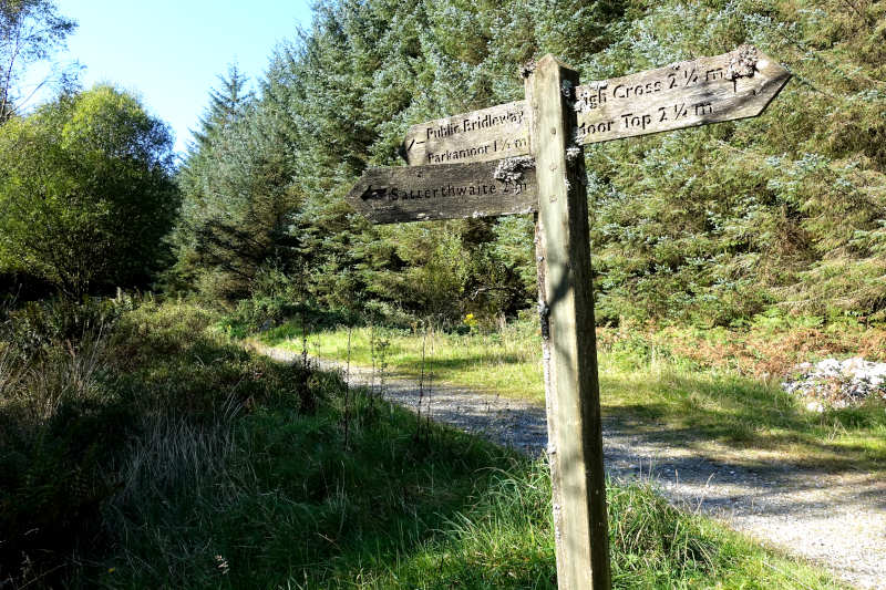 A wooden sign within the forest, to Parkamoor via a bridleway.