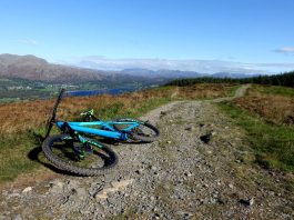 Mountain bike on bridleway with forest and mountains beyond.