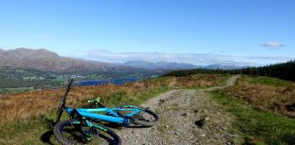 Mountain bike on bridleway with forest and mountains beyond.