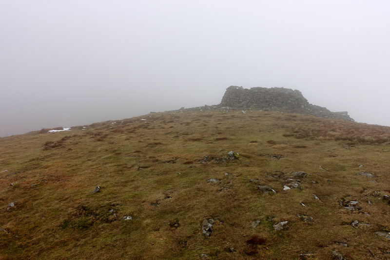 Rock pile shelter emerging from the cloud on Cadair Berwyn