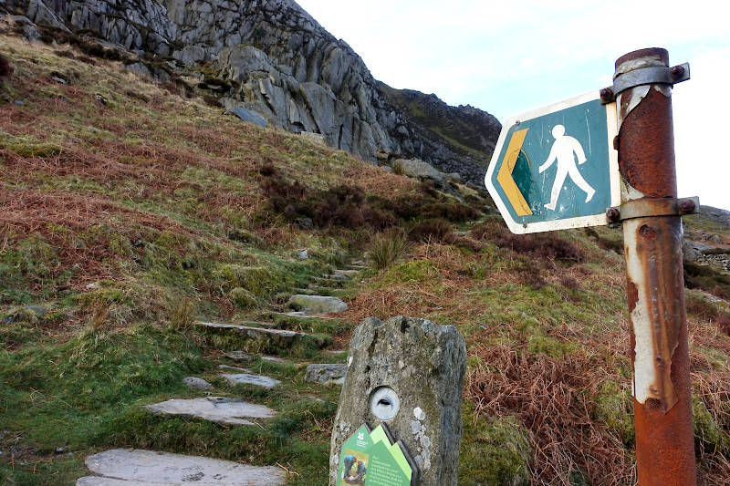 Sign leading the way up rocky stepped mountain path